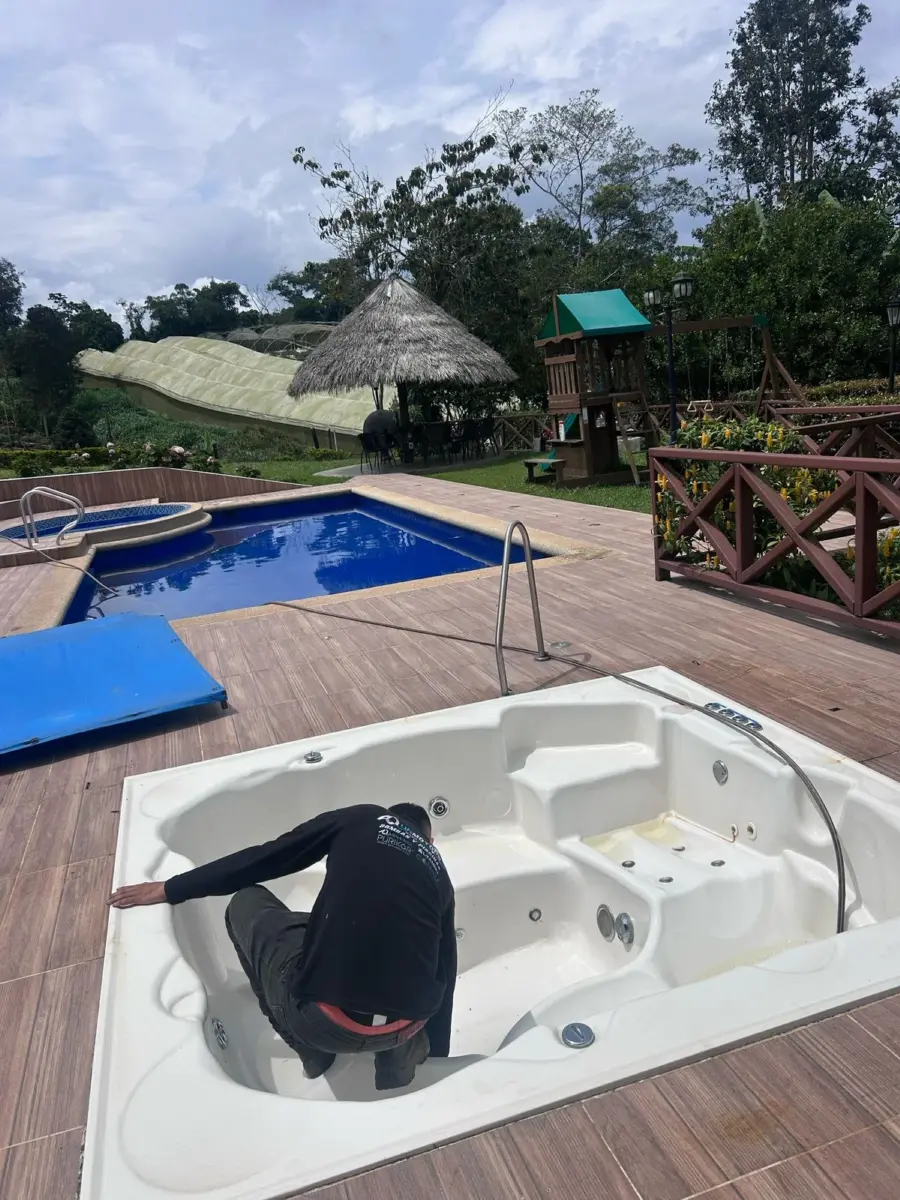 Técnico de Aquamotors revisando un jacuzzi junto a una piscina